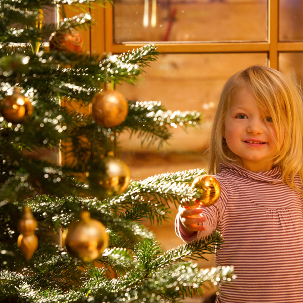Kleines Mädchen schmückt Christbaum