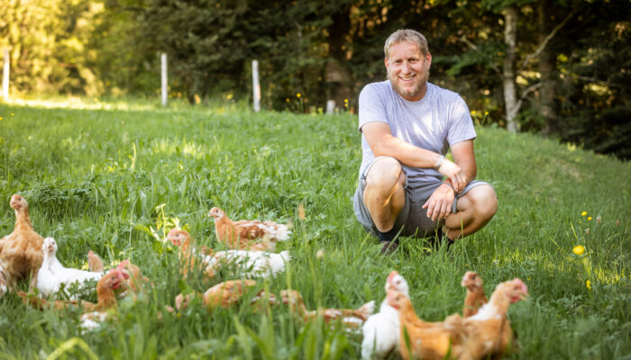 Norbert Schedler Hockt Zusammen Mit Seinen Ländle Wiesenhühnern Auf Der Wiese | Foto: Weissengruber & Partner