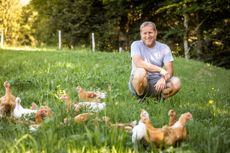 Norbert Schedler Hockt Zusammen Mit Seinen Ländle Wiesenhühnern Auf Der Wiese | Foto: Weissengruber & Partner