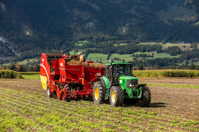 Ein Traktor Zieht Die Erntemaschine Auf Dem Feld Von Rheintaler Feldfrüchte | Foto: Weissengruber & Partner