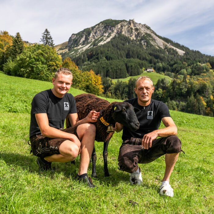 Jürgen Konzett und Sohn Marco hocken gemeinsam mit einem Schaf auf der Weide | Foto: Weissengruber & Partner