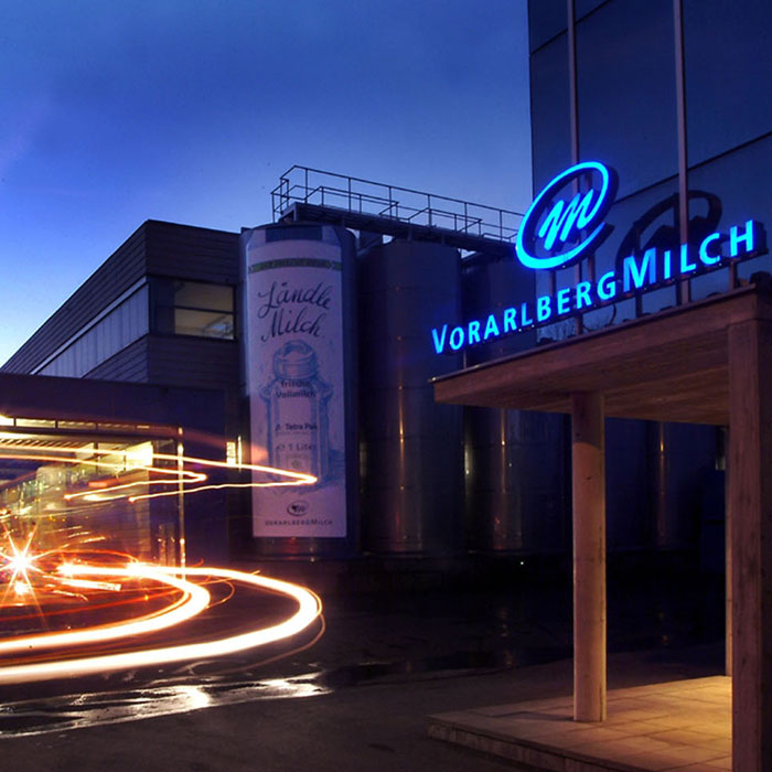 Betriebsgebäude der Vorarlberg Milch bei Nacht mit Lichtspuren