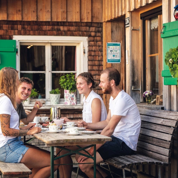 Alpe Stongen Personen am Tisch Foto: Weissengruber und Partner