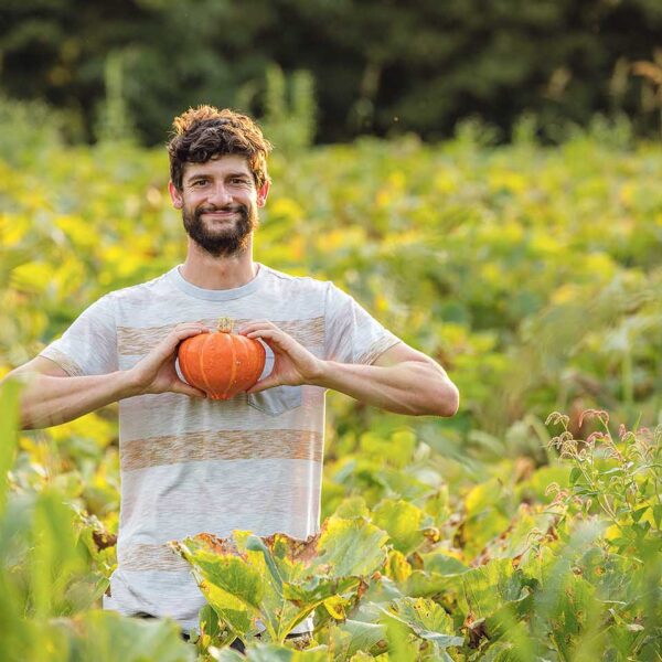 Johannes Hämmerle mit einem Kürbis auf seinem Feld