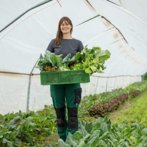 AQUA Garten Leiterin Daniela Vogel Mit Einer Kiste Voller Ländle Bio-Gemüse Im Folientunnel (Foto: Weissengruber)