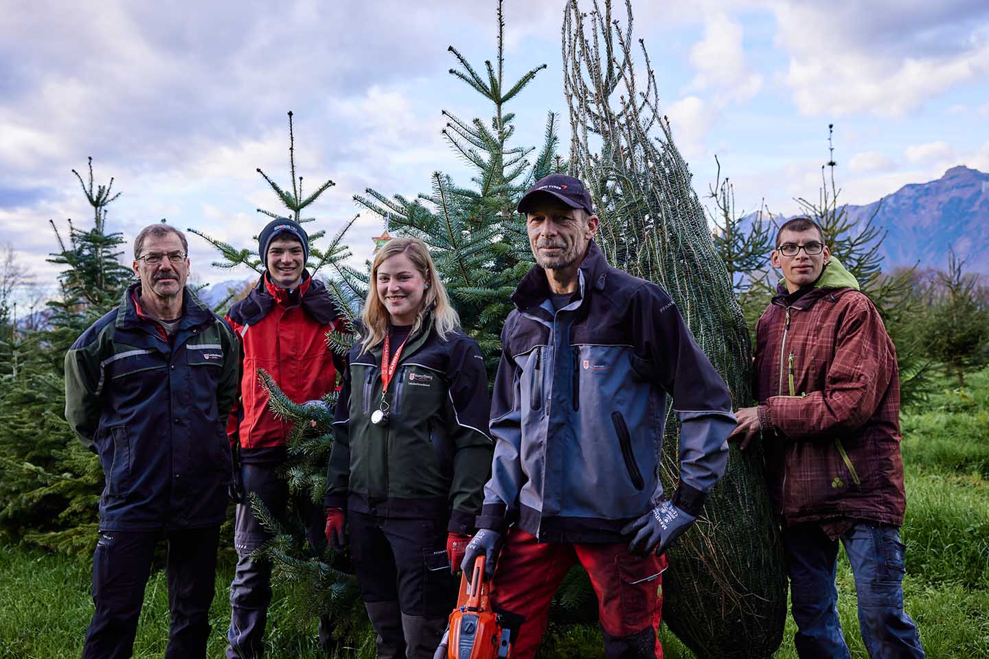 Das Team Des Landesforstgarten Rankweil. 5 Personen Stehen Vor Christbäumen.