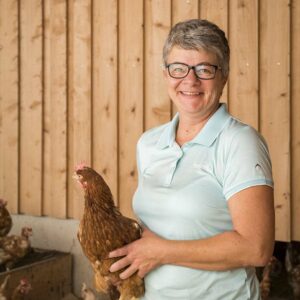 Claudia Giselbrecht Mit Einem Huhn Im Arm Im Freiluft-Vorraum Ihres Hühnerstalls – Foto: Michael Kreyer