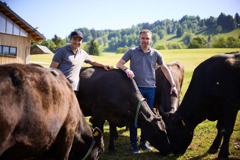 Wolfgang Rigo Und Betriebsleiter Christoph Burtscher Stehen Zwischen Den Rindern Auf Der Weide Vor Dem Petrlehof.
